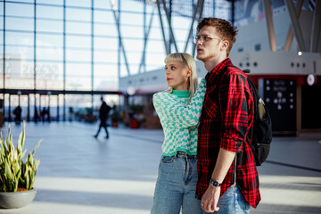 Wall Mural - A traveler couple standing at train station and looking at time table.