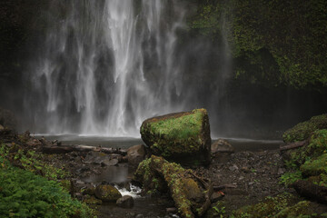 waterfall in the forest huge rock in foreground