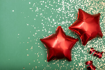 Two red balloons on a green background with glitter