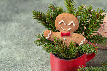 Wall Mural - A gingerbread man is sitting in a red cup surrounded by green pine needles