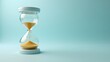 © GMeta - Luxurious gold hourglass on pastel blue background