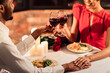 © Prostock-studio - Romantic Date Dinner. Unrecognizable Afro Lovers Clinking Glasses Holding Hands Sitting At Table In Restaurant. Cropped