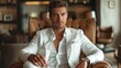 © umar - Stylish man in a white suit seated in a modern lounge