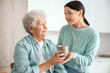 © Pixel-Shot - Senior woman taking cup of tea from her daughter in kitchen