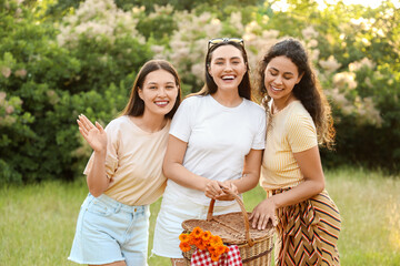 Canvas Print - Female friends with picnic basket in park