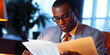 © Lila Patel - Focused Professional: A man intensely studying a legal document in a well-lit office.