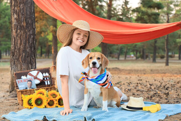 Canvas Print - Young woman with Beagle dog on picnic in forest