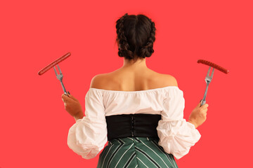 Canvas Print - Young Octoberfest waitress with sausages on red background, back view