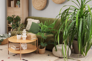 Wall Mural - Interior of living room with green sofa, table and houseplants