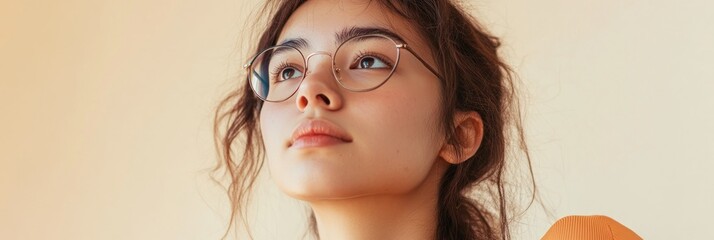 Sticker - A young woman with glasses gazes thoughtfully upwards against a soft background.