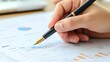 © sk.crafted - Close-up of a hand holding a pen, analyzing financial graphs and charts. Concept of business analysis, market research, and financial planning.