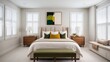 © Shadaw - minimalist bedroom with a neutral color palette. The room features a large bed with a beige upholstered headboard, dressed in white and beige linens, and accented with green and mustard throw pillows.