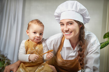 A family enjoys a fun cooking session, playfully covered in flour while engaging with their little ones in a warm kitchen. Mother and son having fun