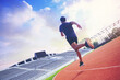 © Panumas - Fit young man running sprinting at the racetrack. Fit runner fitness runner during outdoor workout at racetrack.