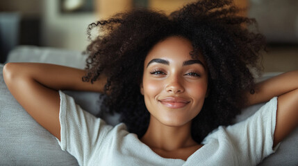 Happy woman relaxing on sofa at home. Smiling girl enjoying day off lying on sofa. Healthy lifestyle, positive people and new home concept.