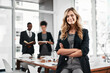 © BestCam/peopleimages.com - Crossed arms, smile and portrait of businesswoman with people in office for leadership in career. Confident, happy and female manager with team of financial advisors for pride of job in workplace.