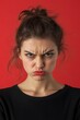 © Yeivaz - A Woman Angry Expression Captured Against a Vibrant Red Background. Female face full of anger