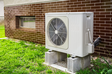 new air source heat pump installed outside of family house
