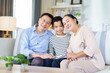 © DG PhotoStock - Asian family with father, mother, and son staying in living room together.