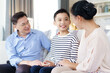 © DG PhotoStock - Asian family with father, mother, and son staying in living room together.