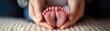 © porpia - A beautiful panoramic close-up of a newborn's tiny feet held gently in a parent's hands, symbolizing care and love.