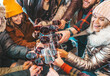 © Davide Angelini - Happy multiracial friends toasting red wine at restaurant terrace - Group of young people wearing winter clothes having fun at outdoors winebar table - Dining life style and friendship concept