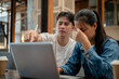 © bongkarn - A stressed and dissatisfied Asian man is discussing issues with his female colleague.