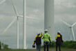 © Montri - A group of wind turbine engineers plans to monitor wind turbine operation and maintenance in a wind farm, a sustainable energy industry concept.
