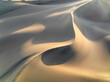 © AmazingAerialAgency - Aerial view of beautiful sand dunes in a serene desert landscape under golden sunlight, Stovepipe Wells, United States.