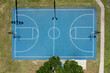 © AmazingAerialAgency - Aerial view of Knecht Park featuring a blue basketball court surrounded by trees and pathways, Palm Bay, United States.