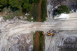 © AmazingAerialAgency - Aerial view of Stavola Aggregate Supply construction site with excavators and machinery surrounded by trees and a river, Fellsmere, United States.