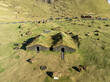 © AmazingAerialAgency - Aerial view of picturesque turf houses on a tranquil hill surrounded by scenic meadows, Vestmannaeyjar, Iceland.
