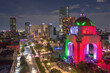 © AmazingAerialAgency - Aerial view of the illuminated revolution monument amidst a vibrant cityscape at night, Cuauhtemoc, Mexico.