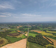 © AmazingAerialAgency - Aerial view of serene countryside with expansive fields and lush greenery, Marlieux, France.