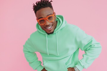 Young man wearing green hoodie dancing in blank space isolated on pink background