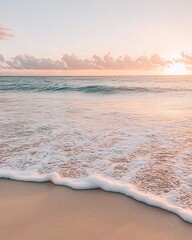 Calm ocean waves gently lapping on a sandy beach at sunset, with a soft pink and orange sky.