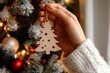 © SEUNGJIN - Wooden Christmas tree decorations. Eco Christmas tree baubles in female hands close-up.