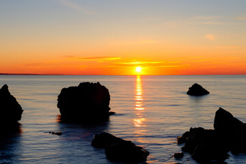 Sun rises over rocks and sea the evening. lifestyle nature. evening sunset sky concept. the sun rises over rocks and sea in the evening. lifestyle in nature. a concept of lifestyle in nature with.