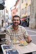 © ajr_images - Handsome man eating in European cafe terrace