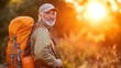 © QITIAN - Smiling senior man with a backpack enjoying a sunset in nature.