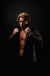 © Alex Vog - Portrait of lovely guy fashion model in unbuttoned leather jacket with abs muscle press posing at black shadow. Stylish young man with perfect muscular sexy torso, studio shot. Copy ad text space