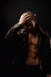 © Alex Vog - Perfect young man with abs muscle press posing in black studio shadow, strong look. Handsome guy fashion model in unbuttoned image leather jacket with lovely muscular sexy torso. Copy ad text space