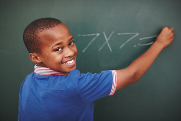 Math, student and portrait at chalkboard in classroom with problem solving, education or learning development. Scholarship, black boy or answer question with multiplication or number lesson at school