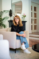 Full length of an attractive woman relaxing in an armchair at home