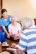 © peopleimages.com - Nursing home, nurse and patient for playing cards with friends, entertainment and laughing. Caregiver, senior people and happy woman with game for problem solving, cognitive function and bonding