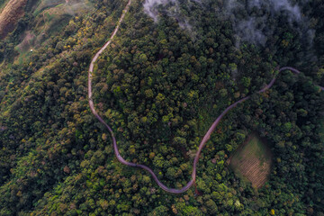 Aerial view road curve on mountain hill tropical forest