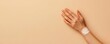 © Jiraporn - Close-up of a hand with a bandage resting against a soft beige background, symbolizing care, healing, and recovery.