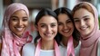 © prachid - Four diverse women smiling, wearing pink ribbons for breast cancer awareness.