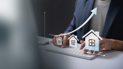 Wall Mural - Real Estate Market Growth Concept. Businessman typing on keyboard with rising house icons and graph, symbolizing real estate market growth and investment trends.