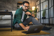 © Miljan Živković - Adult man work from home at home and sit on the floor